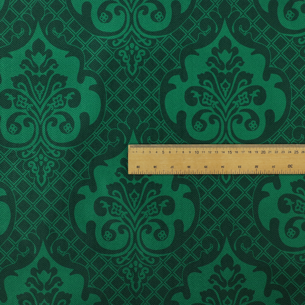 The design showcases large, ornate floral medallions and scrolling acanthus leaves in a vibrant green hue, set against a darker, forest green background. A fine diagonal lattice grid creates a diamond pattern in the spaces between the motifs, and the material displays a distinct woven texture that adds depth and classic character to the design.