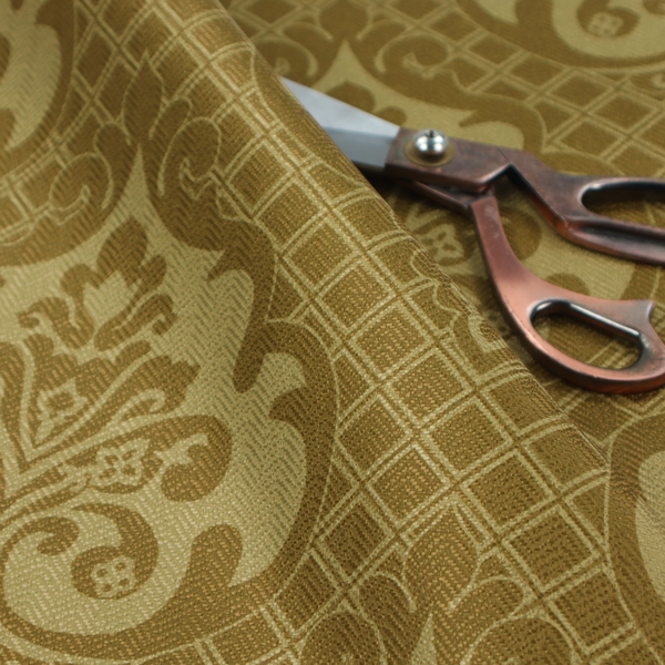 The design showcases large, ornate floral medallions and scrolling acanthus leaves in a muted tan shade, set against a rich ochre background. A fine diagonal lattice grid creates a diamond pattern in the spaces between the motifs, and the material displays a clear woven texture that adds depth and a subtle sheen to the pattern.
