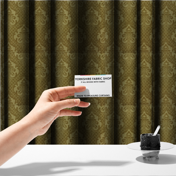 The fabric used to create these made-to-measure curtains has a design that showcases large, ornate floral medallions and scrolling acanthus leaves in a muted tan shade, set against a rich ochre background. A fine diagonal lattice grid creates a diamond pattern in the spaces between the motifs, and the material displays a clear woven texture that adds depth and a subtle sheen to the pattern.