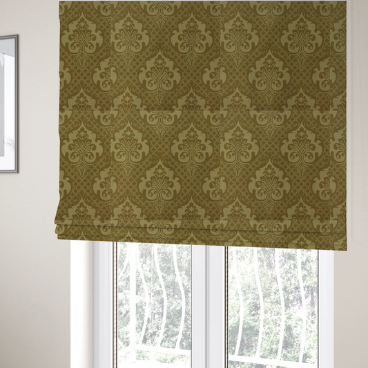 The fabric used to create these Roman blinds has a design that showcases large, ornate floral medallions and scrolling acanthus leaves in a muted tan shade, set against a rich ochre background. A fine diagonal lattice grid creates a diamond pattern in the spaces between the motifs, and the material displays a clear woven texture that adds depth and a subtle sheen to the pattern.