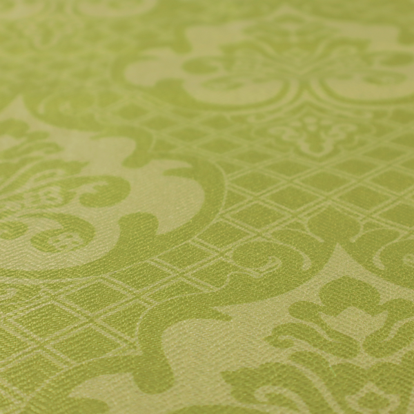 A lime green damask pattern on a textured fabric. The design features large, ornate floral medallions with stylized acanthus leaves, arranged in a repeating grid.