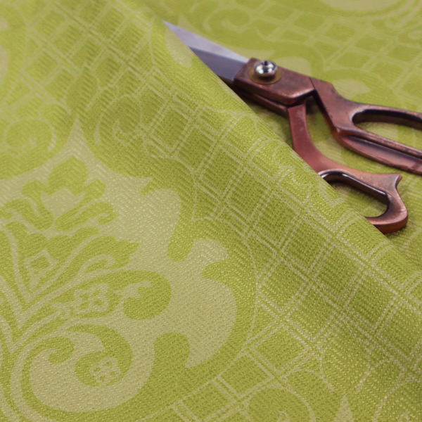 A lime green damask pattern on a textured fabric. The design features large, ornate floral medallions with stylized acanthus leaves, arranged in a repeating grid.