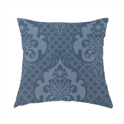 The fabric used to create this handmade cushion has a dusty blue and steel grey damask pattern on a textured fabric. Large, ornate floral motifs with stylized acanthus leaves are arranged in a repeating grid. These medallions are a lighter, cool-toned blue-grey set against a darker navy-blue background.