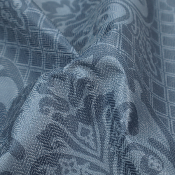 A dusty blue and steel grey damask pattern on a textured fabric. Large, ornate floral motifs with stylized acanthus leaves are arranged in a repeating grid. These medallions are a lighter, cool-toned blue-grey set against a darker navy-blue background.