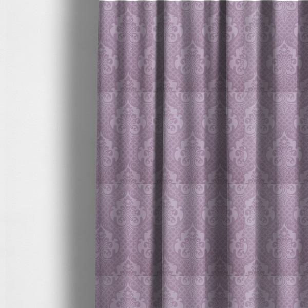 The fabric used to create these made-to-measure curtains has a design that features large, ornate floral medallions and scrolling acanthus leaves in a light lavender shade, set against a slightly darker mauve background. A fine diagonal lattice grid fills the background between the motifs, and the material shows a clear woven texture that provides visual depth to the tonal design.