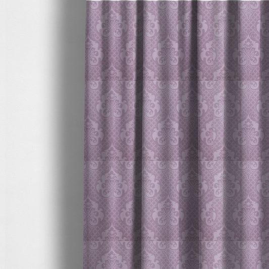 The fabric used to create these made-to-measure curtains has a design that features large, ornate floral medallions and scrolling acanthus leaves in a light lavender shade, set against a slightly darker mauve background. A fine diagonal lattice grid fills the background between the motifs, and the material shows a clear woven texture that provides visual depth to the tonal design.