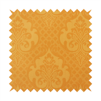 An orange damask pattern on a textured fabric. Large, ornate floral motifs and scrolling acanthus leaves are arranged in a repeating grid. These motifs are rendered in a soft peach shade against a more saturated, vibrant orange background.