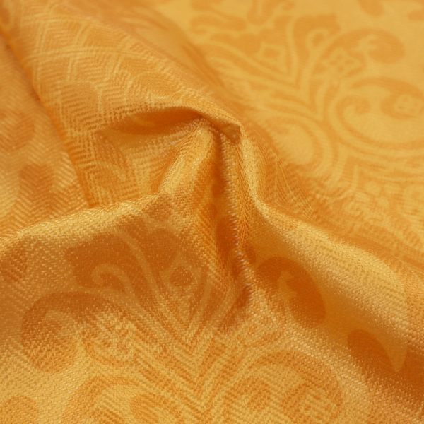 An orange damask pattern on a textured fabric. Large, ornate floral motifs and scrolling acanthus leaves are arranged in a repeating grid. These motifs are rendered in a soft peach shade against a more saturated, vibrant orange background.