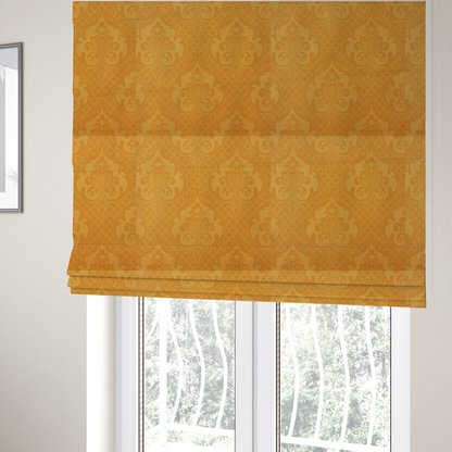 The fabric used to create these Roman blinds has an orange damask pattern on a textured fabric. Large, ornate floral motifs and scrolling acanthus leaves are arranged in a repeating grid. These motifs are rendered in a soft peach shade against a more saturated, vibrant orange background.