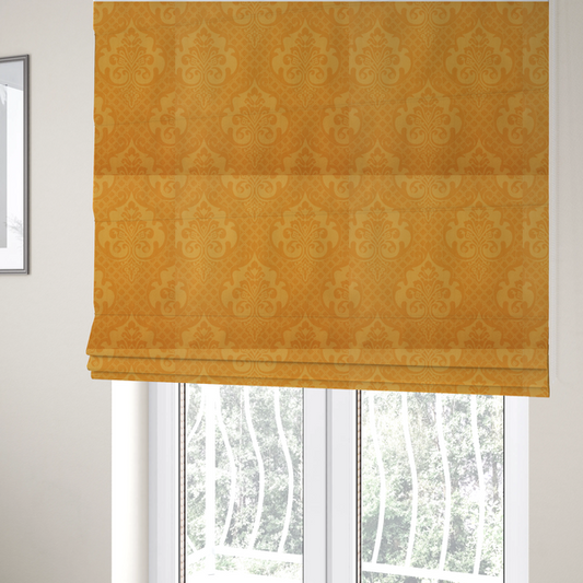 The fabric used to create these Roman blinds has an orange damask pattern on a textured fabric. Large, ornate floral motifs and scrolling acanthus leaves are arranged in a repeating grid. These motifs are rendered in a soft peach shade against a more saturated, vibrant orange background.