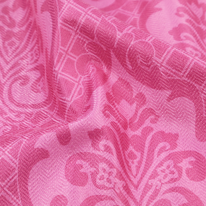 The design features large, ornate floral medallions and scrolling acanthus leaves in a lighter pink shade, set against a saturated magenta-rose background. A fine diagonal lattice grid fills the background between the motifs, and the material shows a clear woven texture that provides visual depth to the traditional design.
