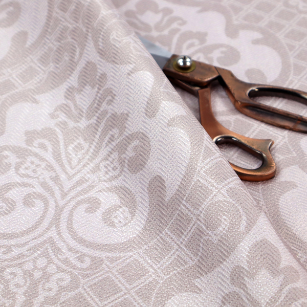 A baby pink and cream damask pattern on a textured fabric. The design features large, ornate floral medallions with stylized acanthus leaf scrolls, arranged in a structured, repeating grid.