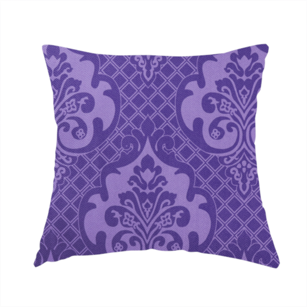 The fabric used to create these handmade cushions has a design that features large, ornate floral medallions and scrolling acanthus leaves in a lighter violet shade, set against a deep, saturated purple background. A fine diagonal lattice grid fills the background between the motifs, and the material displays a clear woven texture that adds structural depth and a sophisticated sheen to the tonal design.