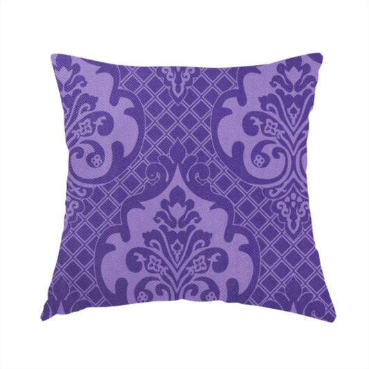 The fabric used to create these handmade cushions has a design that features large, ornate floral medallions and scrolling acanthus leaves in a lighter violet shade, set against a deep, saturated purple background. A fine diagonal lattice grid fills the background between the motifs, and the material displays a clear woven texture that adds structural depth and a sophisticated sheen to the tonal design.