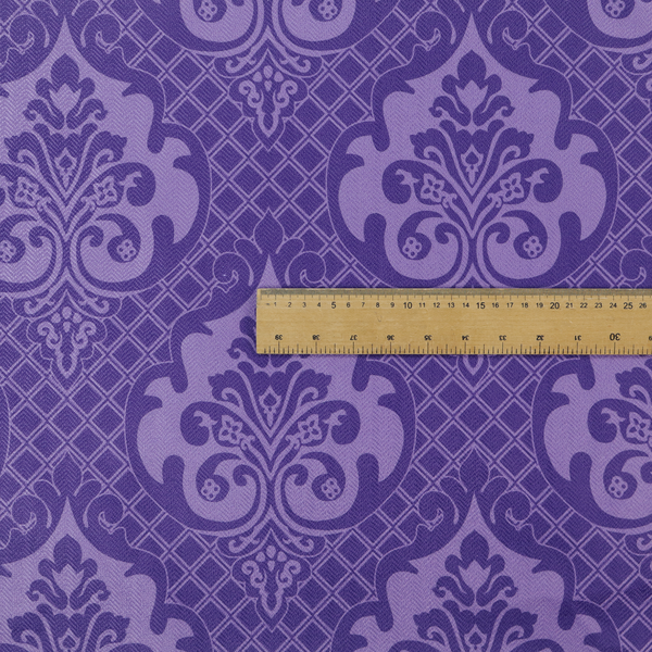 The design features large, ornate floral medallions and scrolling acanthus leaves in a lighter violet shade, set against a deep, saturated purple background. A fine diagonal lattice grid fills the background between the motifs, and the material displays a clear woven texture that adds structural depth and a sophisticated sheen to the tonal design.