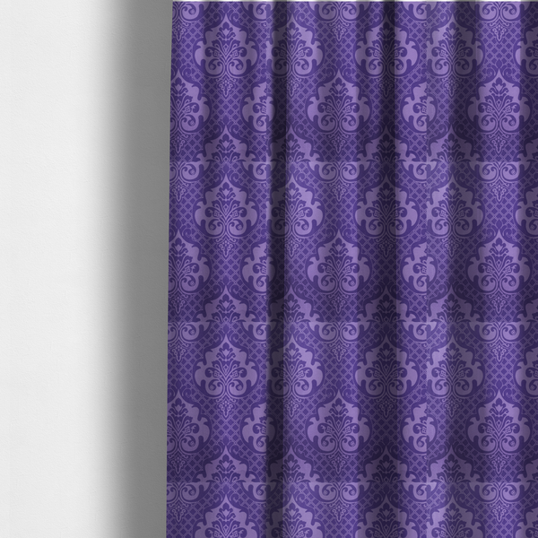 The fabric used to create these made-to-measure curtains has a design that features large, ornate floral medallions and scrolling acanthus leaves in a lighter violet shade, set against a deep, saturated purple background. A fine diagonal lattice grid fills the background between the motifs, and the material displays a clear woven texture that adds structural depth and a sophisticated sheen to the tonal design.
