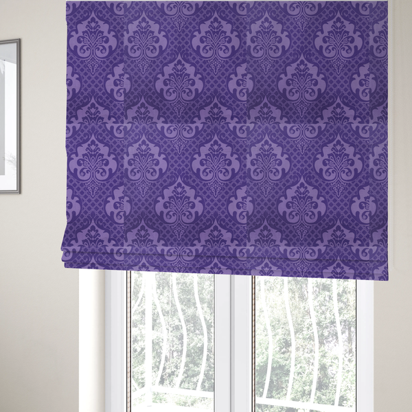 The fabric used to create these Roman blinds has a design that features large, ornate floral medallions and scrolling acanthus leaves in a lighter violet shade, set against a deep, saturated purple background. A fine diagonal lattice grid fills the background between the motifs, and the material displays a clear woven texture that adds structural depth and a sophisticated sheen to the tonal design.