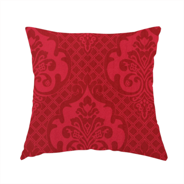 The fabric used to create these handmade cushions has a design that features large, ornate floral medallions and scrolling acanthus leaves in a slightly lighter shade of red, creating a tonal, high-contrast effect. A fine diagonal lattice grid fills the background between the motifs, and the material shows a clear woven texture that adds depth and a traditional feel to the design.