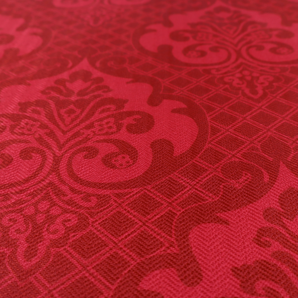 The design features large, ornate floral medallions and scrolling acanthus leaves in a slightly lighter shade of red, creating a tonal, high-contrast effect. A fine diagonal lattice grid fills the background between the motifs, and the material shows a clear woven texture that adds depth and a traditional feel to the design.