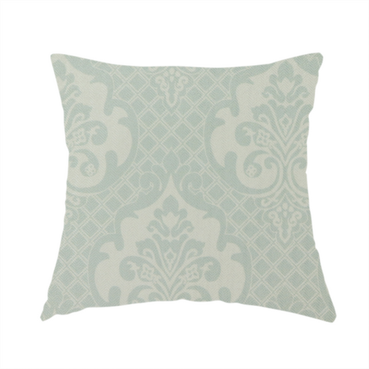 The fabric used to create this handmade cushion has a design that showcases large, ornate floral medallions and scrolling acanthus leaves in a light silver shade, set against a slightly darker grey-white background. A fine diagonal lattice grid creates a diamond pattern in the negative space between the motifs, and the material displays a clear woven texture that adds a sophisticated, metallic-like shimmer to the pattern.