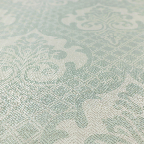 The design showcases large, ornate floral medallions and scrolling acanthus leaves in a light silver shade, set against a slightly darker grey-white background. A fine diagonal lattice grid creates a diamond pattern in the negative space between the motifs, and the material displays a clear woven texture that adds a sophisticated, metallic-like shimmer to the pattern.