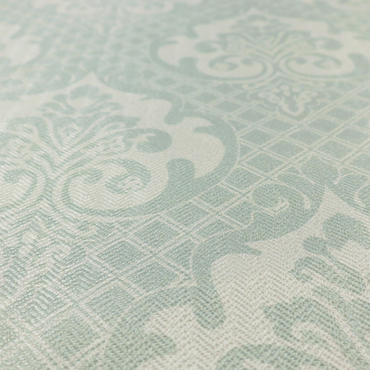 The design showcases large, ornate floral medallions and scrolling acanthus leaves in a light silver shade, set against a slightly darker grey-white background. A fine diagonal lattice grid creates a diamond pattern in the negative space between the motifs, and the material displays a clear woven texture that adds a sophisticated, metallic-like shimmer to the pattern.
