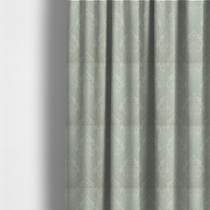 The fabric used to create these made-to-measure curtains has a design that showcases large, ornate floral medallions and scrolling acanthus leaves in a light silver shade, set against a slightly darker grey-white background. A fine diagonal lattice grid creates a diamond pattern in the negative space between the motifs, and the material displays a clear woven texture that adds a sophisticated, metallic-like shimmer to the pattern.