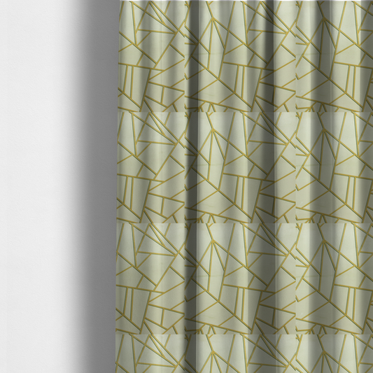 The fabric used to create these made-to-measure curtains, features a geometric, fractured glass pattern. The design consists of irregular, sharp-angled polygons in a pale sage green or muted seafoam hue. These shapes are separated by thick, shimmering gold metallic lines that appear slightly recessed or embossed, creating a high-contrast, mosaic-like effect.