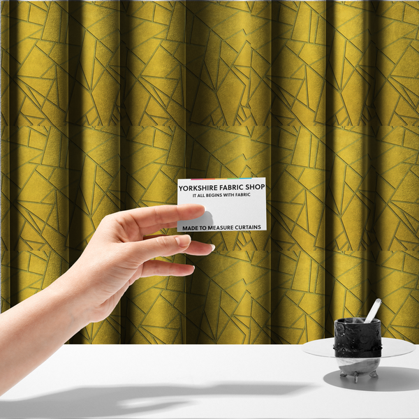 The fabric used to create these made-to-measure curtains is a luxurious mustard yellow fabric featuring a bold geometric, fractured pattern. The design is composed of sharp, irregular polygons separated by embossed tone-on-tone lines in a slightly darker, olive-tinted gold.