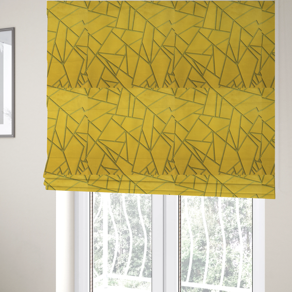The fabric used to create these Roman blinds is a luxurious mustard yellow fabric featuring a bold geometric, fractured pattern. The design is composed of sharp, irregular polygons separated by embossed tone-on-tone lines in a slightly darker, olive-tinted gold.