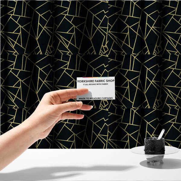 The fabric used to create these made-to-measure curtains is a high-contrast black and gold fabric featuring a fractured, geometric mosaic design. The deep, matte black background is intersected by a network of sharp, metallic gold lines that form irregular, angular polygons. The pattern resembles a web of shimmering gold veins or a stylized shattered-glass effect, giving the textile a luxurious, Art Deco-inspired aesthetic.