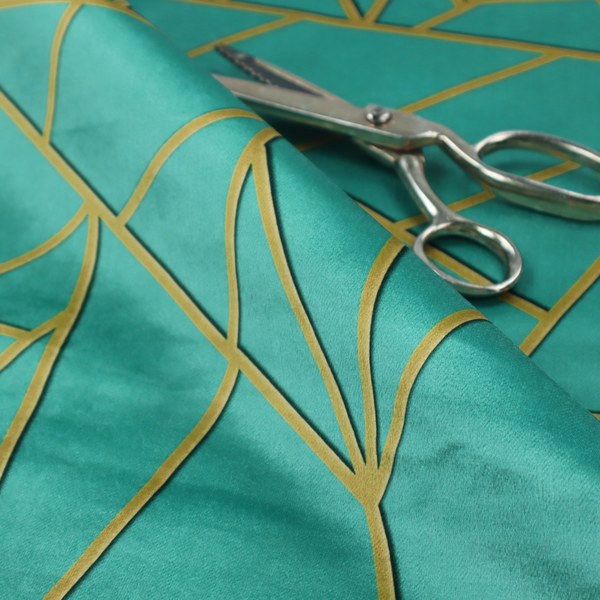 A close-up of a luxurious teal or bright turquoise fabric featuring a fractured, geometric mosaic pattern. The vibrant, plush background is divided by a network of shimmering metallic gold lines that form sharp, irregular polygons. The design creates a striking shattered-glass or "cracked ice" effect, blending a high-energy jewel tone with sophisticated, Art Deco-inspired gold linework for a modern, architectural look.