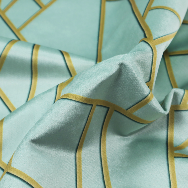 A close-up of a luxurious light aqua or pale sky blue fabric featuring a fractured, geometric mosaic pattern. The soft, matte background is segmented by a network of embossed metallic gold lines that create sharp, irregular polygons. This "cracked ice" or shattered-glass effect pairs a serene, cool-toned pastel with warm, shimmering gold linework for a sophisticated and modern Art Deco-inspired look.