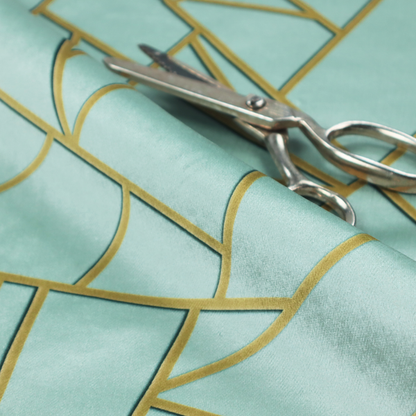 A close-up of a luxurious light aqua or pale sky blue fabric featuring a fractured, geometric mosaic pattern. The soft, matte background is segmented by a network of embossed metallic gold lines that create sharp, irregular polygons. This "cracked ice" or shattered-glass effect pairs a serene, cool-toned pastel with warm, shimmering gold linework for a sophisticated and modern Art Deco-inspired look.