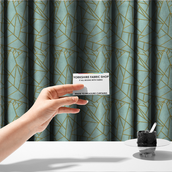 The fabric used to create these made-to-measure curtains is a luxurious light aqua or pale sky blue fabric featuring a fractured, geometric mosaic pattern. The soft, matte background is segmented by a network of embossed metallic gold lines that create sharp, irregular polygons. This "cracked ice" or shattered-glass effect pairs a serene, cool-toned pastel with warm, shimmering gold linework for a sophisticated and modern Art Deco-inspired look.