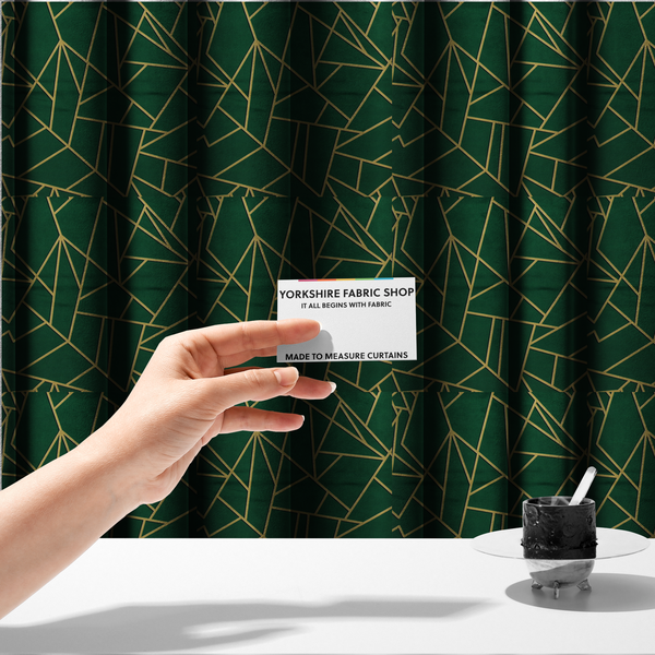 The fabric used to create these made-to-measure curtains is a luxurious forest green fabric featuring a fractured, geometric mosaic pattern. The dark, velvety background is segmented by a network of recessed metallic gold lines that form sharp, irregular polygons. This "shattered-glass" effect pairs a sophisticated, deep-toned base with shimmering, Art Deco-inspired gold linework for a dramatic and architectural look.