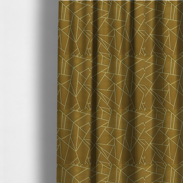 The fabric used to create these made-to-measure curtains is a luxurious olive gold or antique brass-coloured fabric featuring a fractured, geometric mosaic pattern. The rich, matte background is segmented by a network of recessed tone-on-tone lines in a slightly lighter, shimmering shade. This "cracked ice" or shattered-glass effect creates a subtle, sophisticated 3D texture, blending mid-century modern influence with contemporary Art Deco elegance.