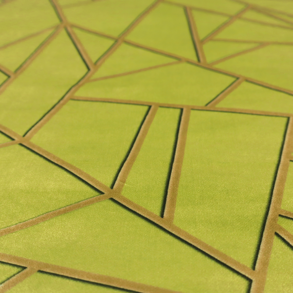 A close-up of a luxurious lime or chartreuse green fabric featuring a fractured, geometric mosaic pattern. The vibrant, matte background is segmented by a network of recessed metallic gold lines that form sharp, irregular polygons. This "shattered-glass" effect combines a high-energy, citrus-toned base with shimmering, Art Deco-inspired gold linework for a bold and architectural look.