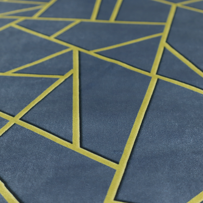 A close-up of a luxurious slate grey fabric featuring a fractured, geometric mosaic pattern. The deep, matte background is segmented by a network of recessed metallic gold lines that form sharp, irregular polygons. This "shattered-glass" effect creates a striking visual contrast, blending the cool, dark tones of the textile with shimmering, Art Deco-inspired accents for a modern, high-end look.