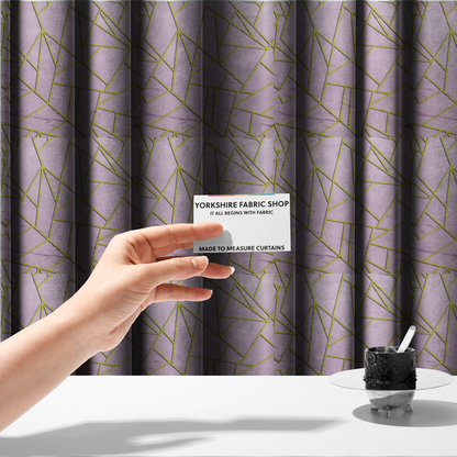 The fabric used to create these made-to-measure curtains is a luxurious lavender or lilac fabric featuring a fractured, geometric mosaic pattern. The soft, matte background is segmented by a network of recessed metallic gold lines that form sharp, irregular polygons. This "shattered-glass" effect creates a sophisticated visual contrast, blending the delicate, feminine tones of the textile with shimmering, Art Deco-inspired gold accents for a clean and contemporary look.