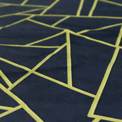 A close-up of a luxurious navy blue fabric featuring a fractured, geometric mosaic pattern. The dark, matte background is segmented by a network of recessed metallic gold lines that form sharp, irregular polygons. This "shattered-glass" or "cracked ice" effect creates a striking visual contrast, blending a deep, oceanic base with shimmering, Art Deco-inspired gold linework for a sophisticated, architectural look.