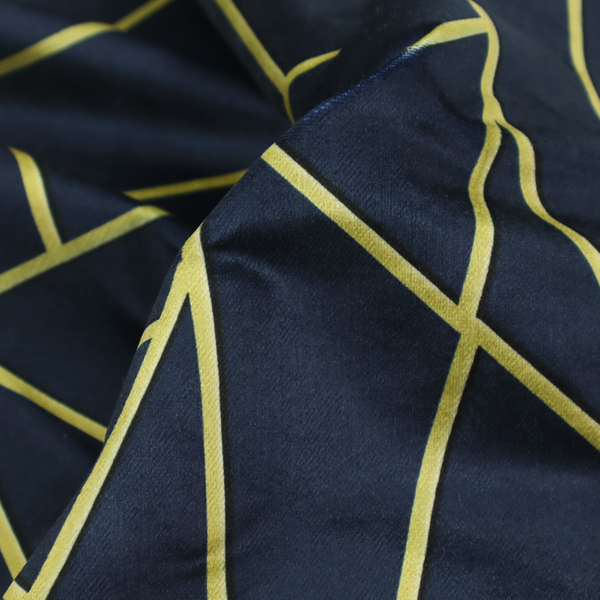 A close-up of a luxurious navy blue fabric featuring a fractured, geometric mosaic pattern. The dark, matte background is segmented by a network of recessed metallic gold lines that form sharp, irregular polygons. This "shattered-glass" or "cracked ice" effect creates a striking visual contrast, blending a deep, oceanic base with shimmering, Art Deco-inspired gold linework for a sophisticated, architectural look.
