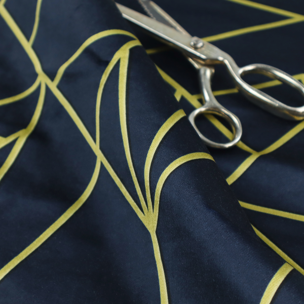 A close-up of a luxurious navy blue fabric featuring a fractured, geometric mosaic pattern. The dark, matte background is segmented by a network of recessed metallic gold lines that form sharp, irregular polygons. This "shattered-glass" or "cracked ice" effect creates a striking visual contrast, blending a deep, oceanic base with shimmering, Art Deco-inspired gold linework for a sophisticated, architectural look.