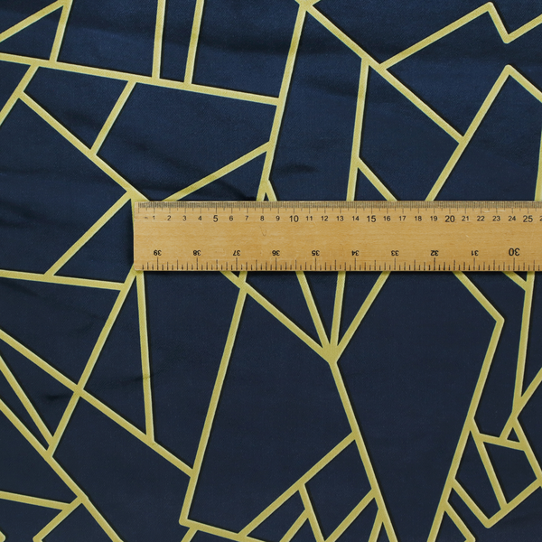 A close-up of a luxurious navy blue fabric featuring a fractured, geometric mosaic pattern. The dark, matte background is segmented by a network of recessed metallic gold lines that form sharp, irregular polygons. This "shattered-glass" or "cracked ice" effect creates a striking visual contrast, blending a deep, oceanic base with shimmering, Art Deco-inspired gold linework for a sophisticated, architectural look.