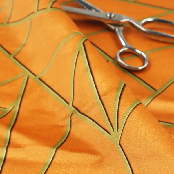 A close-up of a luxurious bright orange or apricot fabric featuring a fractured, geometric mosaic pattern. The warm, vibrant background is segmented by a network of recessed metallic gold lines that form sharp, irregular polygons. This "shattered-glass" effect pairs a bold, citrus-toned base with shimmering, Art Deco-inspired gold linework, creating a high-contrast and architectural look with a subtle 3D texture.