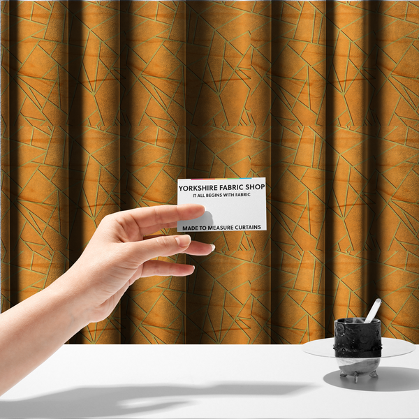 The fabric used to create these made-to-measure curtains is a luxurious bright orange or apricot fabric featuring a fractured, geometric mosaic pattern. The warm, vibrant background is segmented by a network of recessed metallic gold lines that form sharp, irregular polygons. This "shattered-glass" effect pairs a bold, citrus-toned base with shimmering, Art Deco-inspired gold linework, creating a high-contrast and architectural look with a subtle 3D texture.