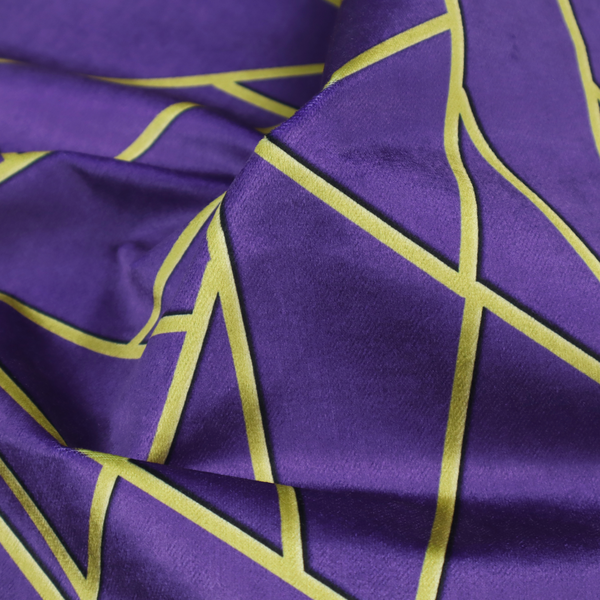 A close-up of a luxurious deep purple or violet fabric featuring a fractured, geometric mosaic pattern. The dark, matte background is segmented by a network of recessed metallic gold lines that form sharp, irregular polygons. This "shattered-glass" effect creates a dramatic visual contrast, blending the rich, royal tones of the textile with shimmering, Art Deco-inspired gold accents for a bold and sophisticated look.