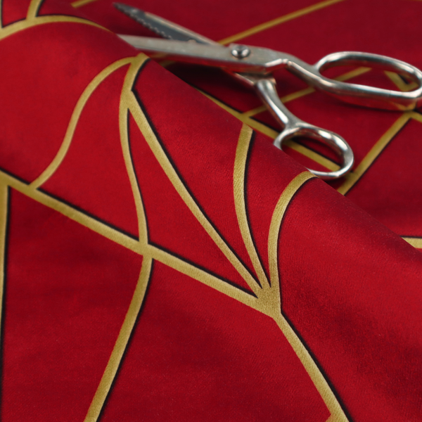 A close-up of a luxurious vibrant red fabric featuring a fractured, geometric mosaic pattern. The rich, matte background is segmented by a network of recessed metallic gold lines that form sharp, irregular polygons. This "shattered-glass" or "cracked ice" effect creates a striking visual contrast, blending the intense red base with shimmering, Art Deco-inspired gold linework for a dramatic and architectural look.