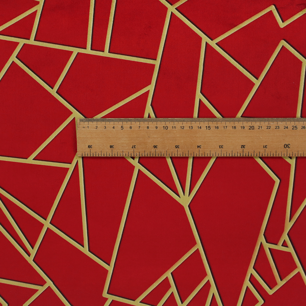 A close-up of a luxurious vibrant red fabric featuring a fractured, geometric mosaic pattern. The rich, matte background is segmented by a network of recessed metallic gold lines that form sharp, irregular polygons. This "shattered-glass" or "cracked ice" effect creates a striking visual contrast, blending the intense red base with shimmering, Art Deco-inspired gold linework for a dramatic and architectural look.