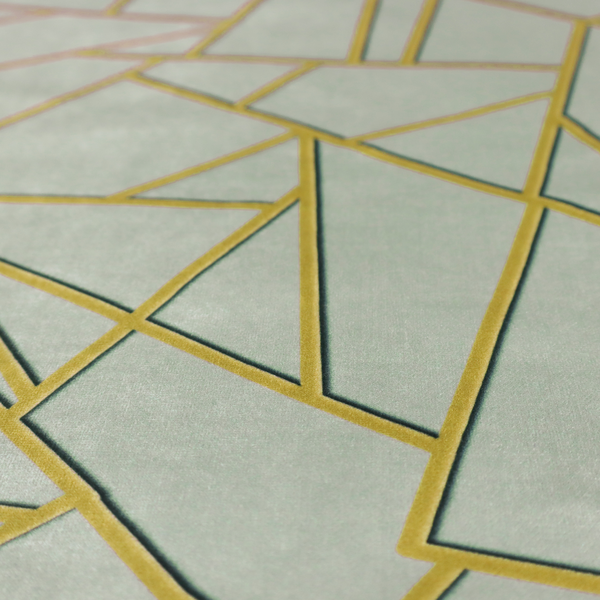 A close-up of a luxurious silver fabric featuring a fractured, geometric mosaic pattern. The soft, matte background is segmented by a network of recessed metallic gold lines that form sharp, irregular polygons. This "shattered-glass" effect creates a calm yet architectural look, blending cool, desaturated tones with shimmering, Art Deco-inspired gold linework for a high-end, contemporary finish.